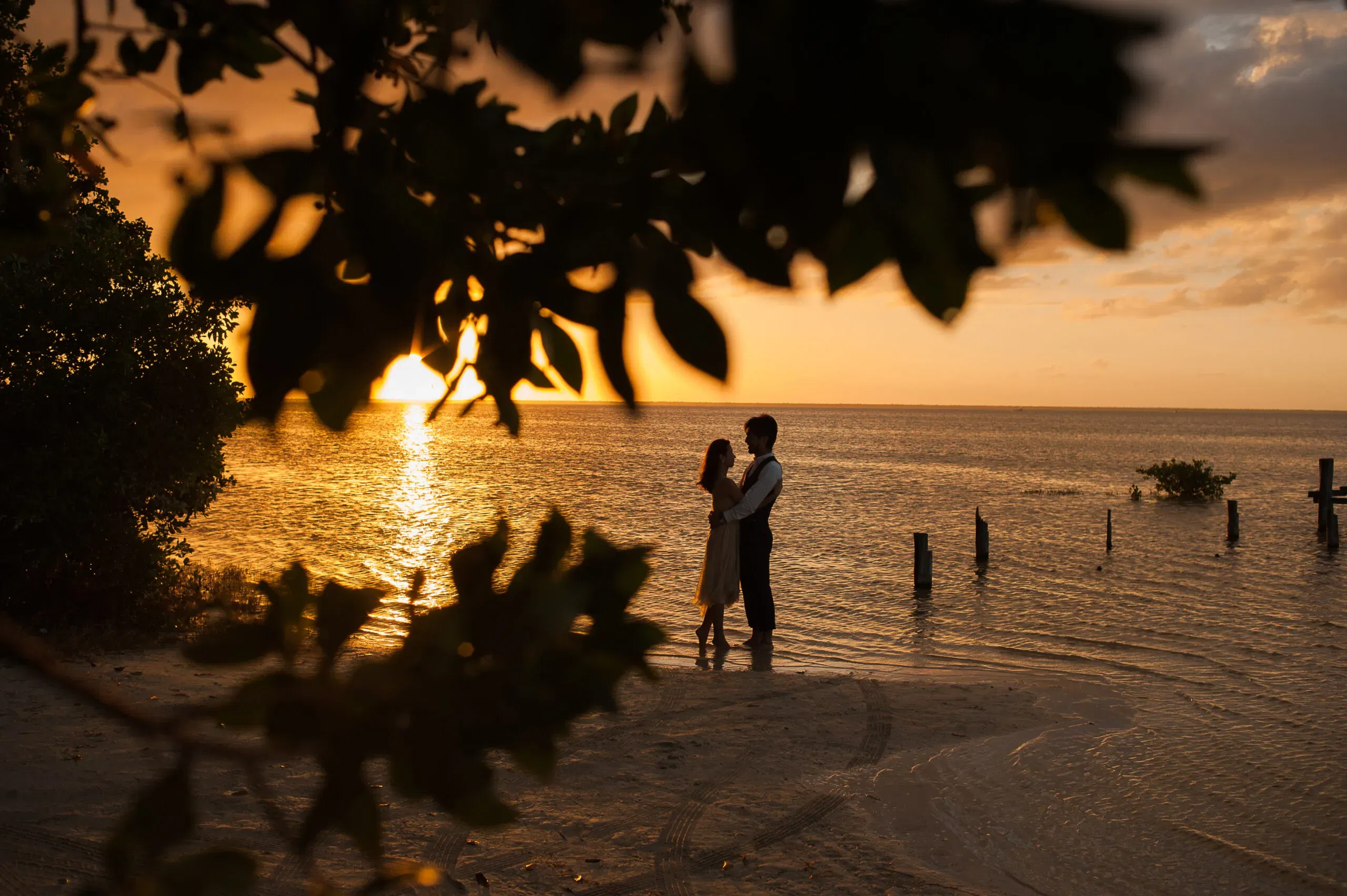 Romantic sunset couple silhouette on Cancun beach - destination wedding photography in Riviera Maya Mexico