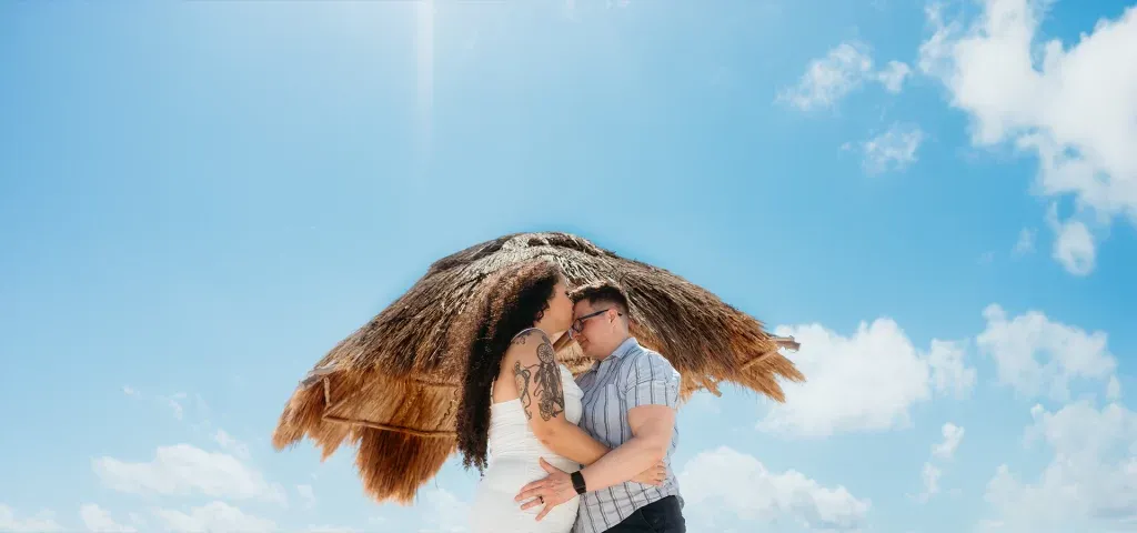 Same sex wedding elopement Couple kissing at Playa Delfines beach wedding, Cancun Mexico