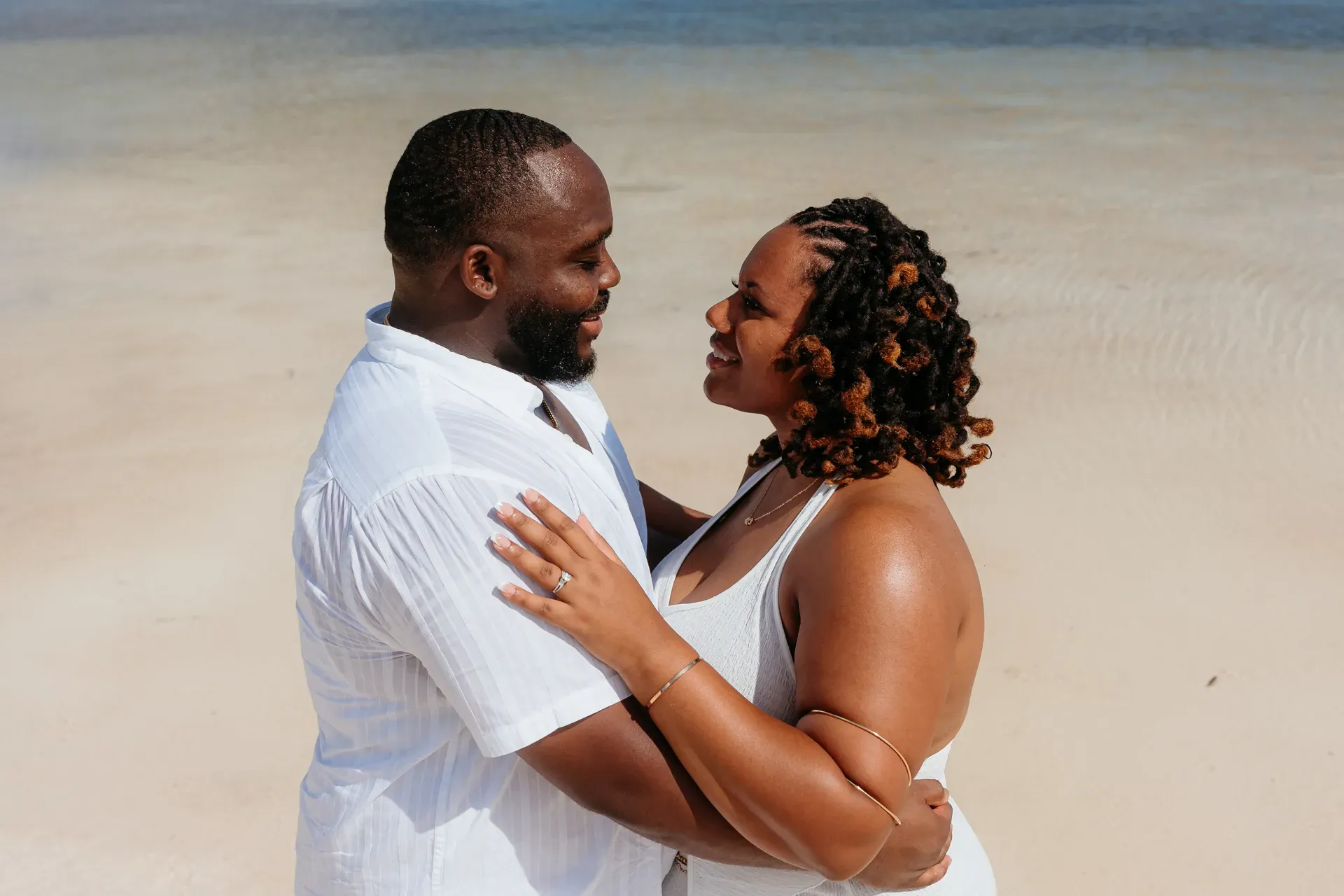 Happy couple just engaged in Cancun, bride-to-be showing engagement ring after surprise proposal in Isla Blanca