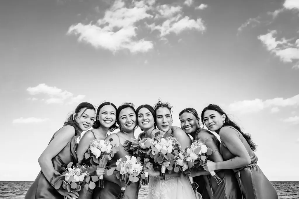 Bride with bridesmaids holding bouquets on Cancun beach - black and white Riviera Maya wedding photography