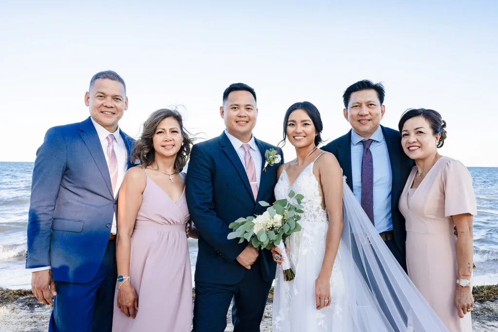 Bride and groom with family on beach wedding day in Cancun Riviera Maya Mexico destination wedding photography