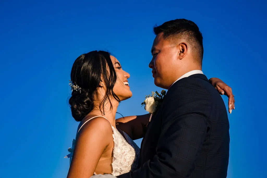 Romantic wedding couple embracing under blue sky in Cancun Mexico destination wedding photography Riviera Maya