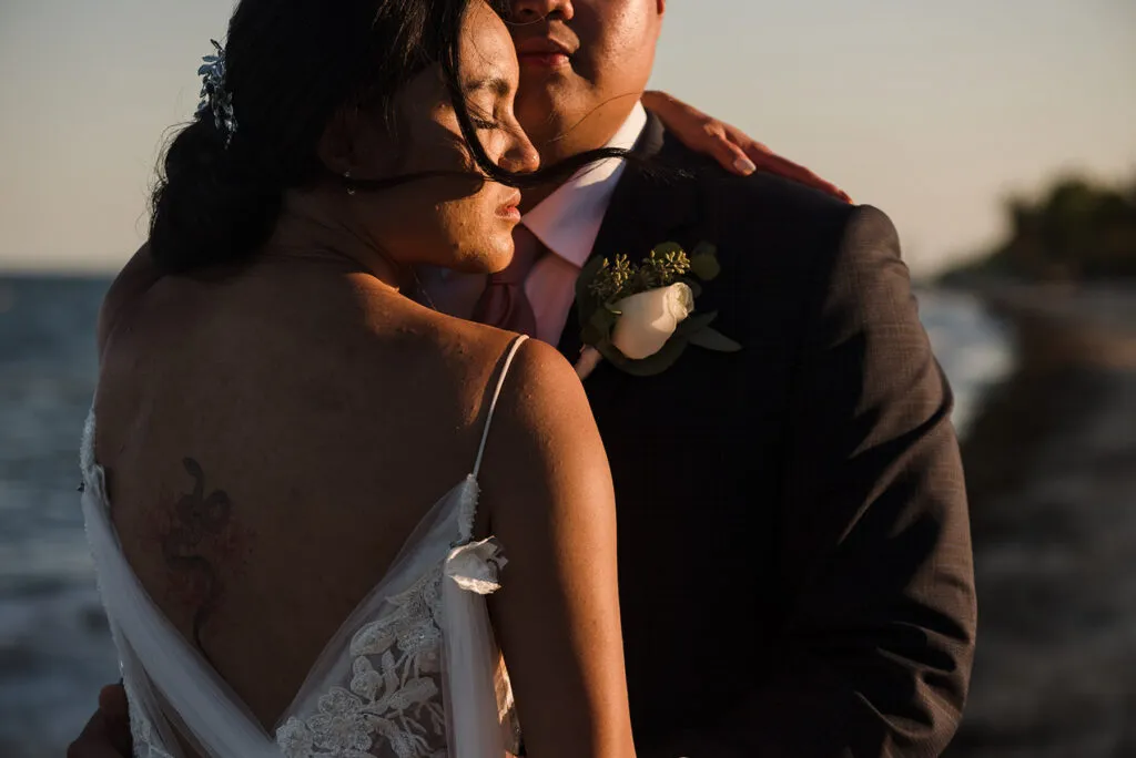 Romantic bride and groom embracing at golden hour sunset wedding photography session in Cancun Riviera Maya Mexico