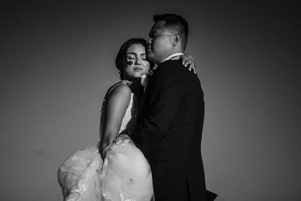 Romantic black and white wedding portrait of couple embracing at sunset in Cancun Riviera Maya Mexico destination wedding