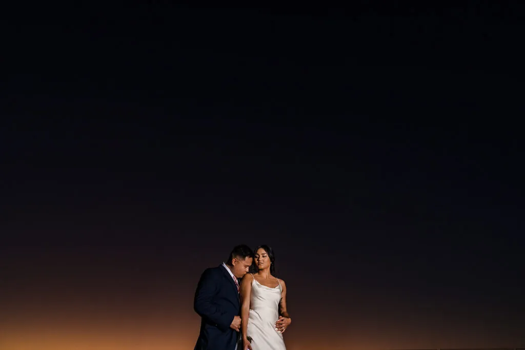 Romantic couple portrait at sunset in Cancun - intimate wedding photography session against dramatic sky in Riviera Maya Mexico