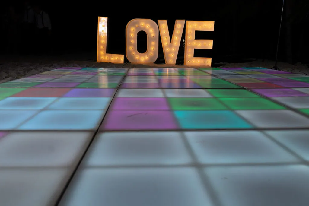 LOVE marquee letters on colorful LED dance floor for romantic wedding reception in Cancun Riviera Maya Mexico