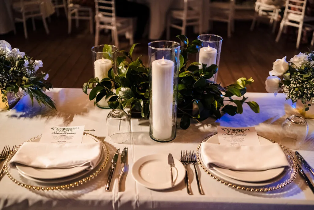 Elegant wedding reception table setting with candles and white flowers at luxury Cancun Riviera Maya venue