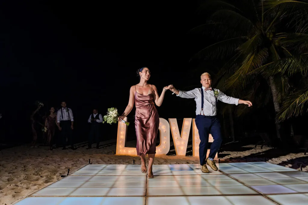 Couple dancing on beach wedding dance floor with LOVE sign in Cancun Riviera Maya Mexico destination wedding photography