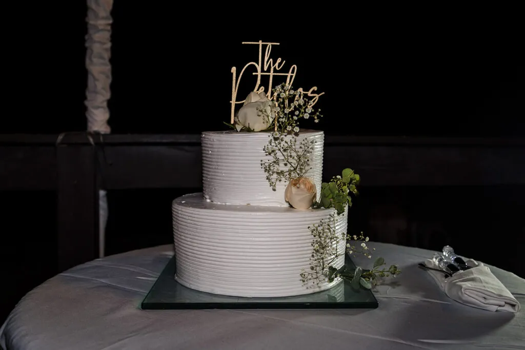 Elegant white wedding cake with greenery decorations at Cancun Riviera Maya destination wedding reception