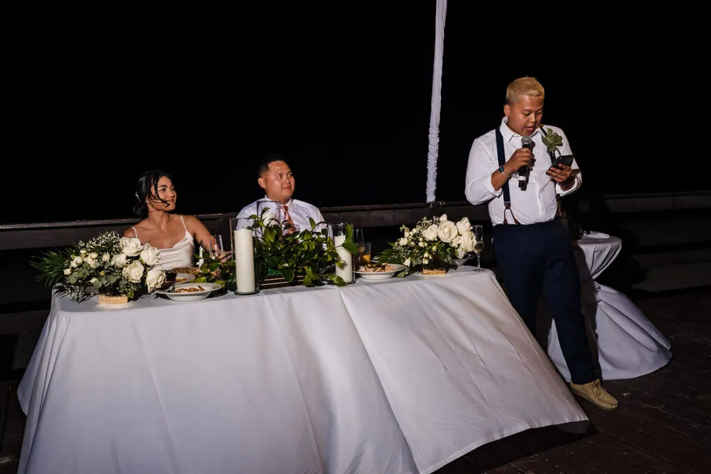 Wedding reception speech at intimate Cancun destination wedding with bride and groom at elegant white table setup