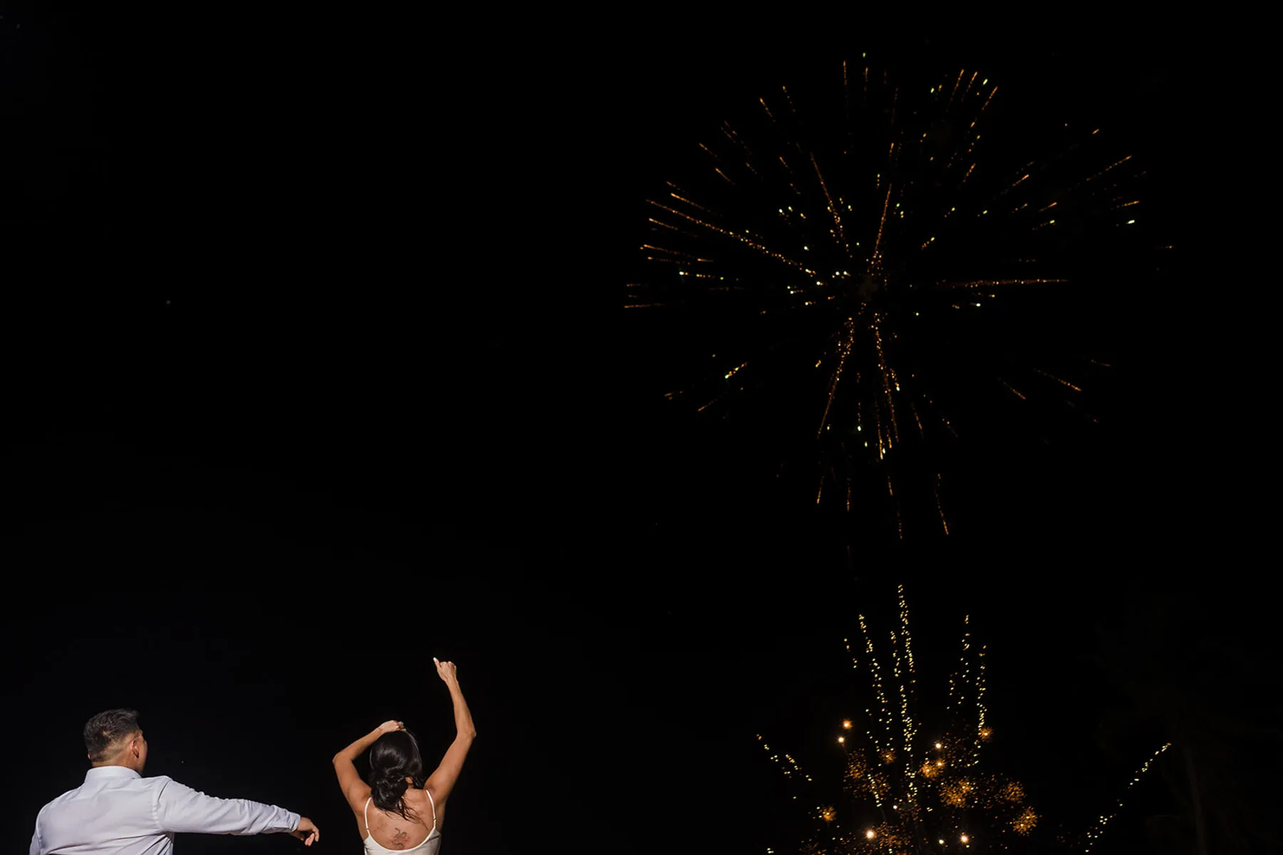 Couple celebrating with fireworks display at night wedding reception in Cancun Riviera Maya Mexico destination wedding