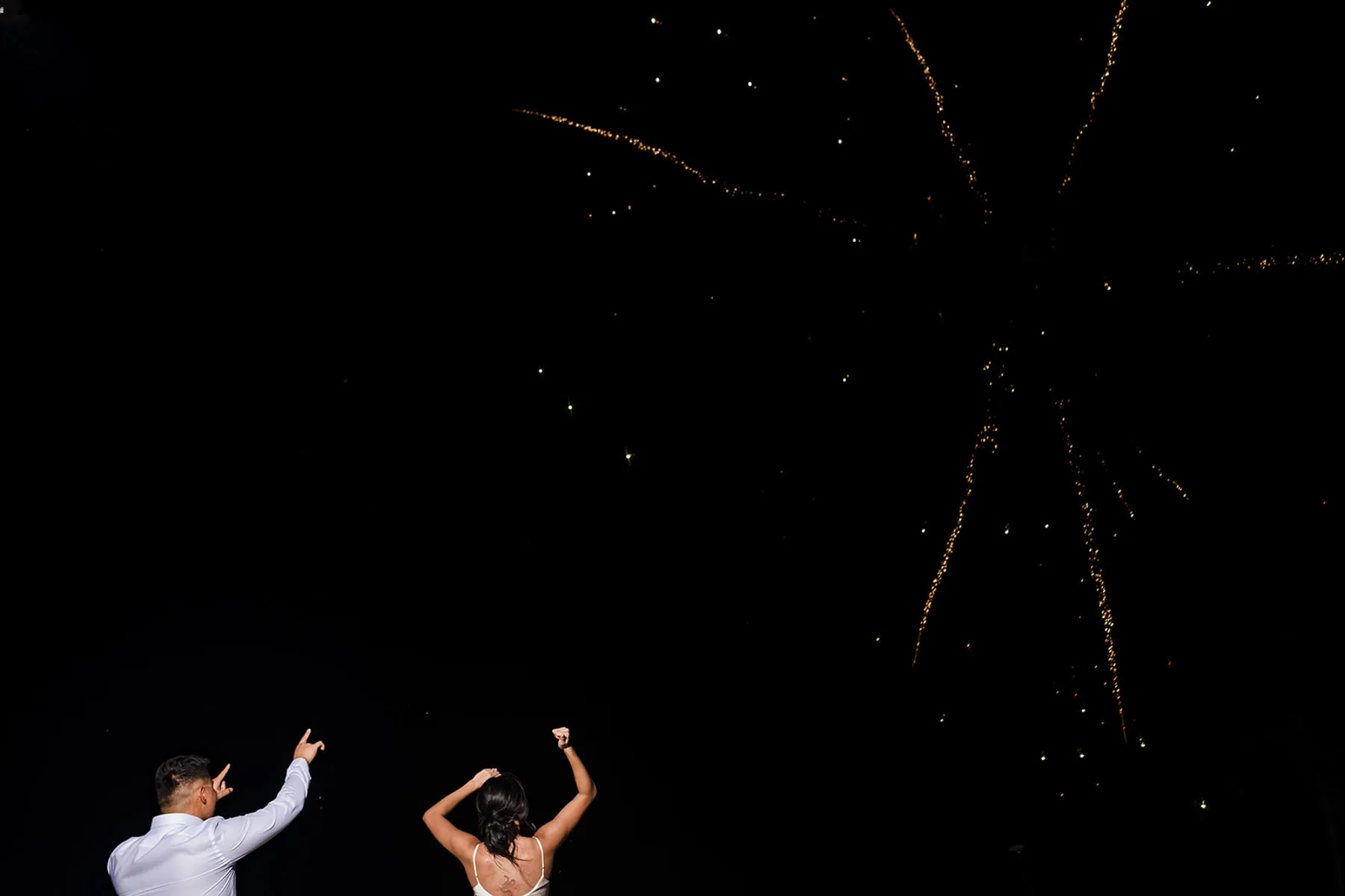 Bride and groom celebrating with fireworks display at night wedding reception in Cancun Riviera Maya Mexico