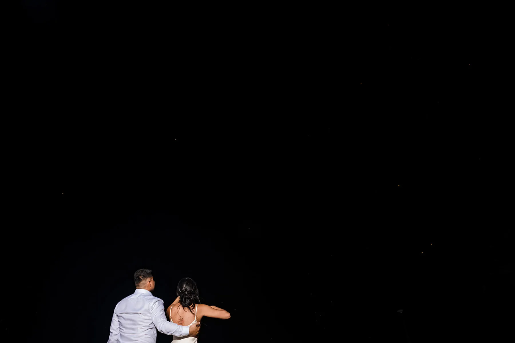 Romantic couple stargazing under night sky in Cancun - intimate wedding photography by Riviera Maya photographer
