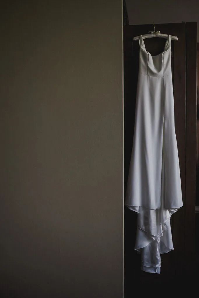 Elegant white wedding dress hanging in luxury hotel room before Cancun Riviera Maya destination wedding ceremony