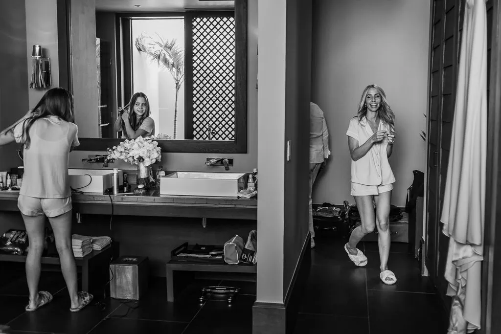 Bride getting ready in luxury Cancun resort bathroom with bridesmaid, destination wedding photography Riviera Maya Mexico