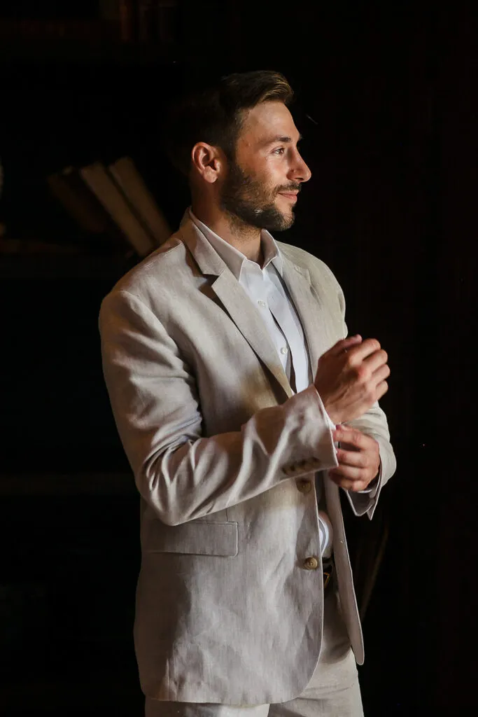 Groom adjusting light linen suit jacket for destination wedding photography session in Cancun Riviera Maya Mexico