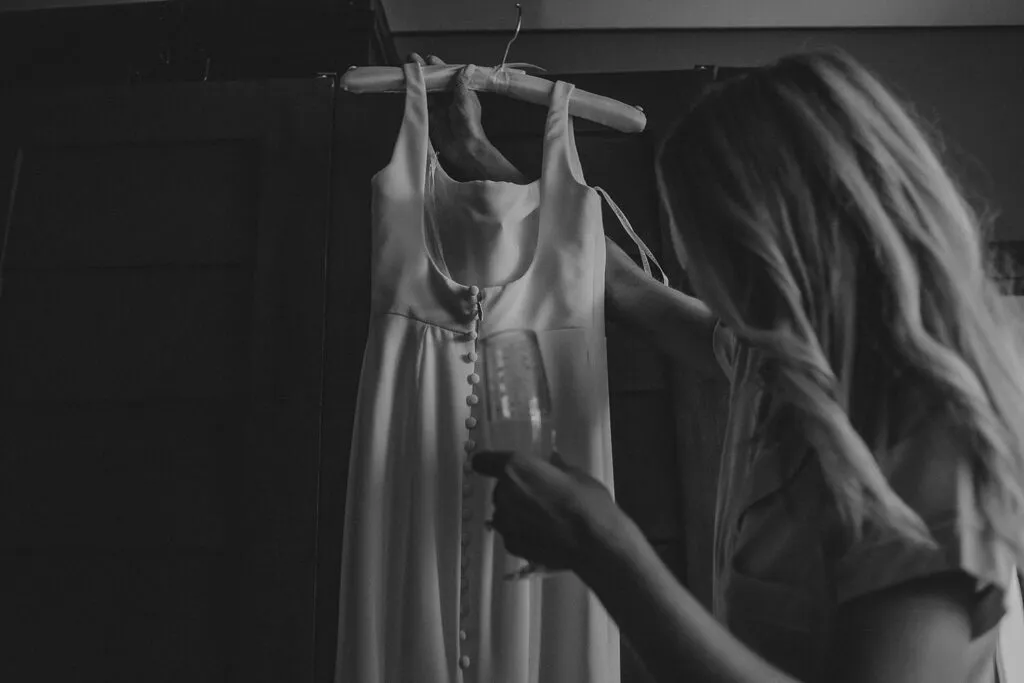 Elegant wedding dress hanging in bridal suite preparation room in Cancun Riviera Maya Mexico destination wedding photography
