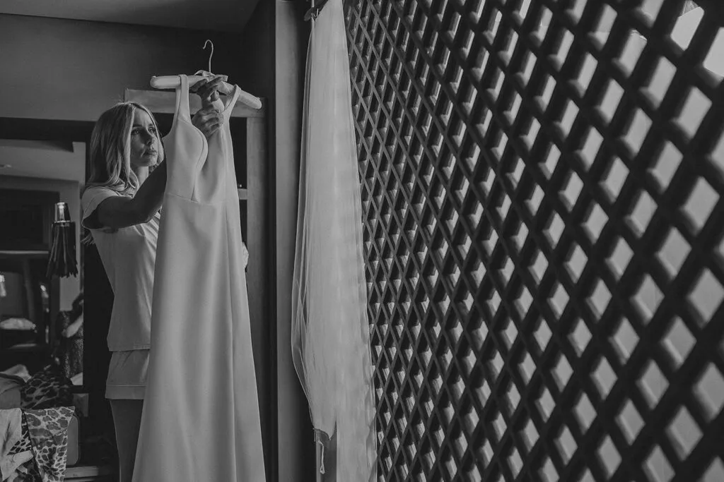 Bride getting ready with wedding dress in Cancun resort room - destination wedding photography Riviera Maya Mexico