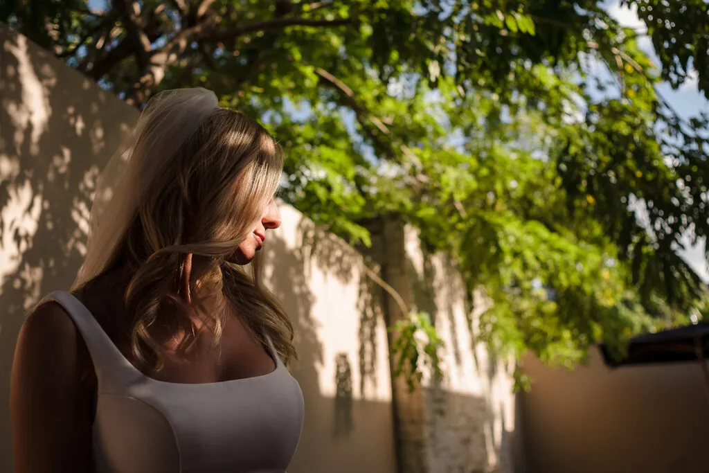 Beautiful bride in white dress under lush tropical trees in Cancun Mexico destination wedding photography session