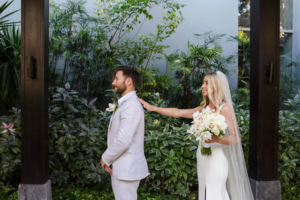 Bride and groom first look moment at tropical Cancun wedding venue with lush greenery and modern architecture