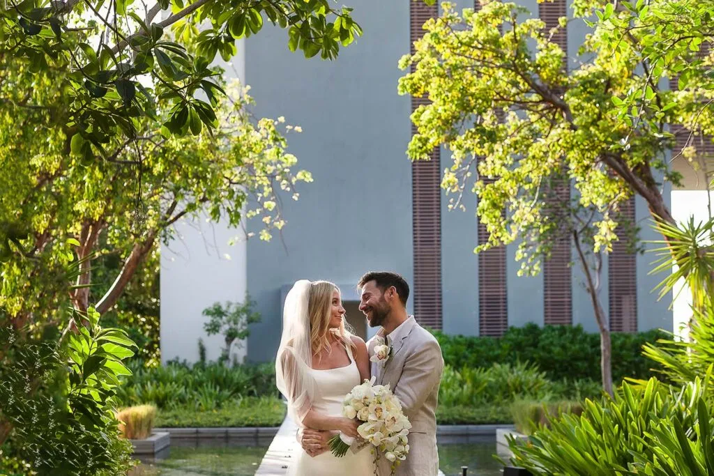 Bride and groom embrace in lush tropical garden at luxury Cancun resort wedding venue in Riviera Maya Mexico