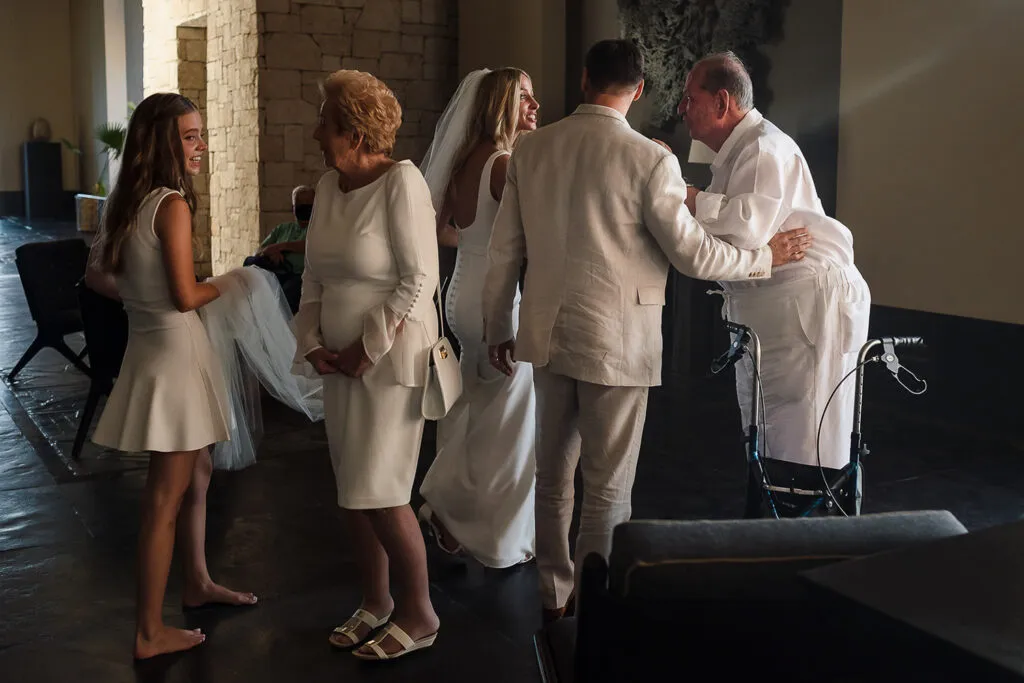 Bride and groom celebrating with family after wedding ceremony at luxury Cancun resort with stone architecture