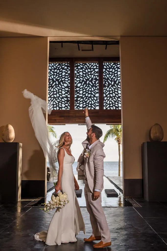 Bride and groom celebrating at luxury Riviera Maya resort wedding with ocean view and tropical palm trees in Cancun Mexico