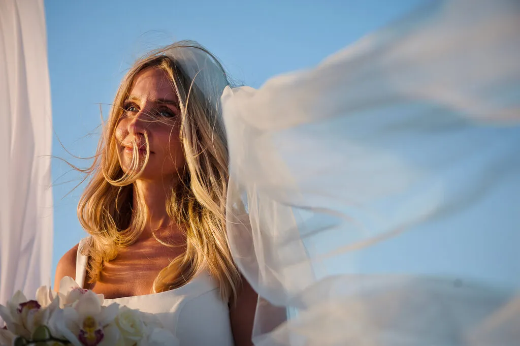 Beautiful bride with flowing veil in golden light during Riviera Maya wedding photography session in Cancun Mexico