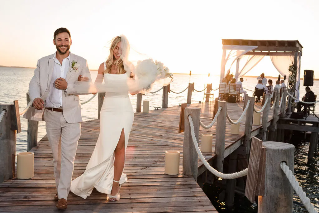 Newlyweds walking on wooden dock at sunset wedding ceremony in Cancun Riviera Maya Mexico destination wedding photography