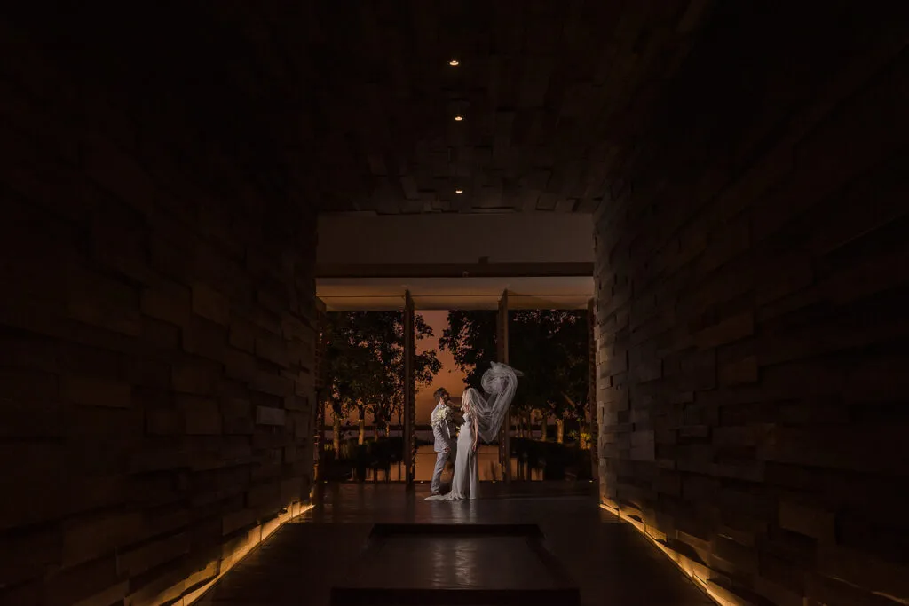 Romantic couple portrait at sunset in Cancun wedding venue with stone archway and golden hour lighting in Riviera Maya Mexico