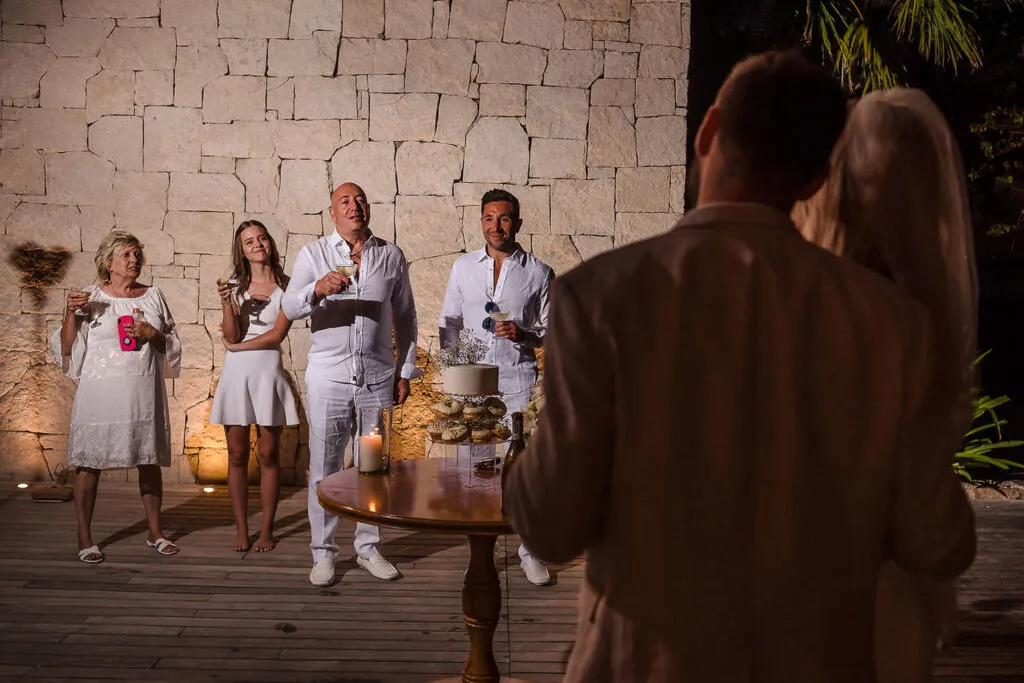 Wedding celebration toast at luxury stone villa in Riviera Maya Mexico with family raising glasses at intimate reception