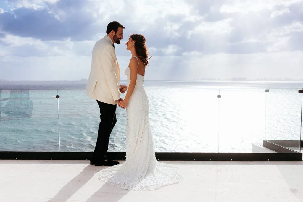 Romantic wedding couple on oceanfront terrace overlooking Caribbean Sea in Cancun Riviera Maya Mexico destination wedding