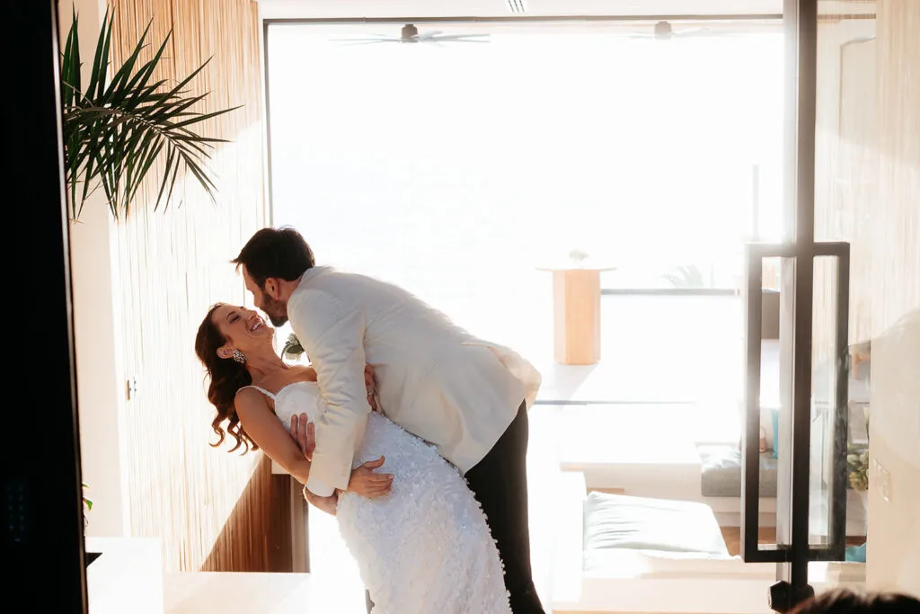 Romantic bride and groom embrace in luxury Cancun resort with ocean view - destination wedding photography Riviera Maya