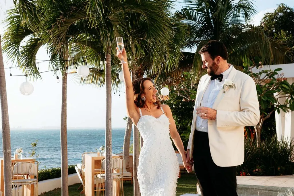 Bride and groom celebrating with champagne at tropical beach wedding in Cancun Riviera Maya Mexico destination wedding