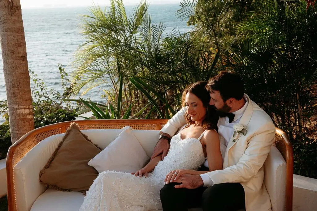 Romantic newlyweds embrace on tropical terrace overlooking Caribbean Sea during Cancun destination wedding photography session