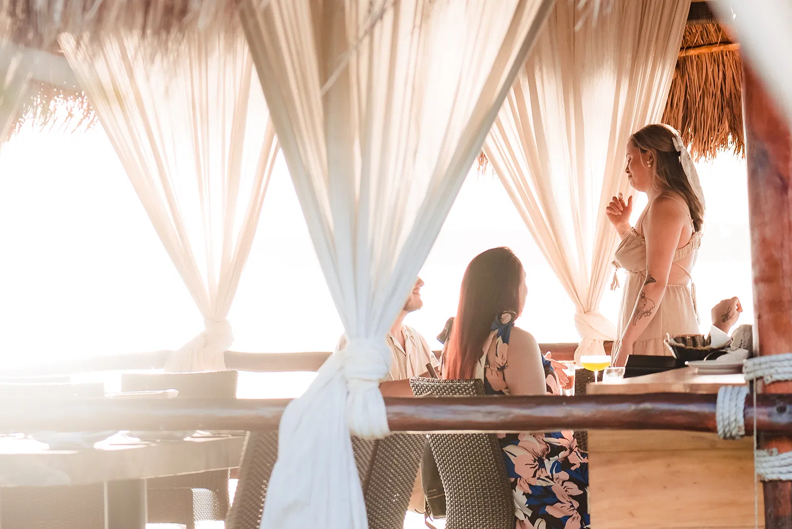 Surprise proposal at Navios restaurant in Cancun at sunset, partner kneeling with ring while being kissed