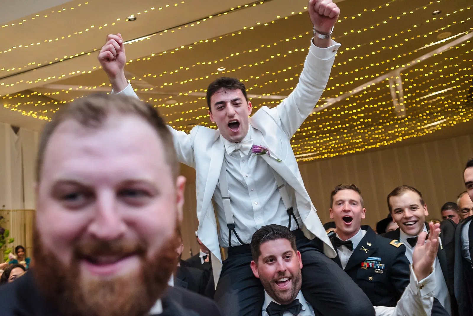 Wedding reception party with groom lifted by friends celebrating at Dreams Natura Resort in Cancun Mexico