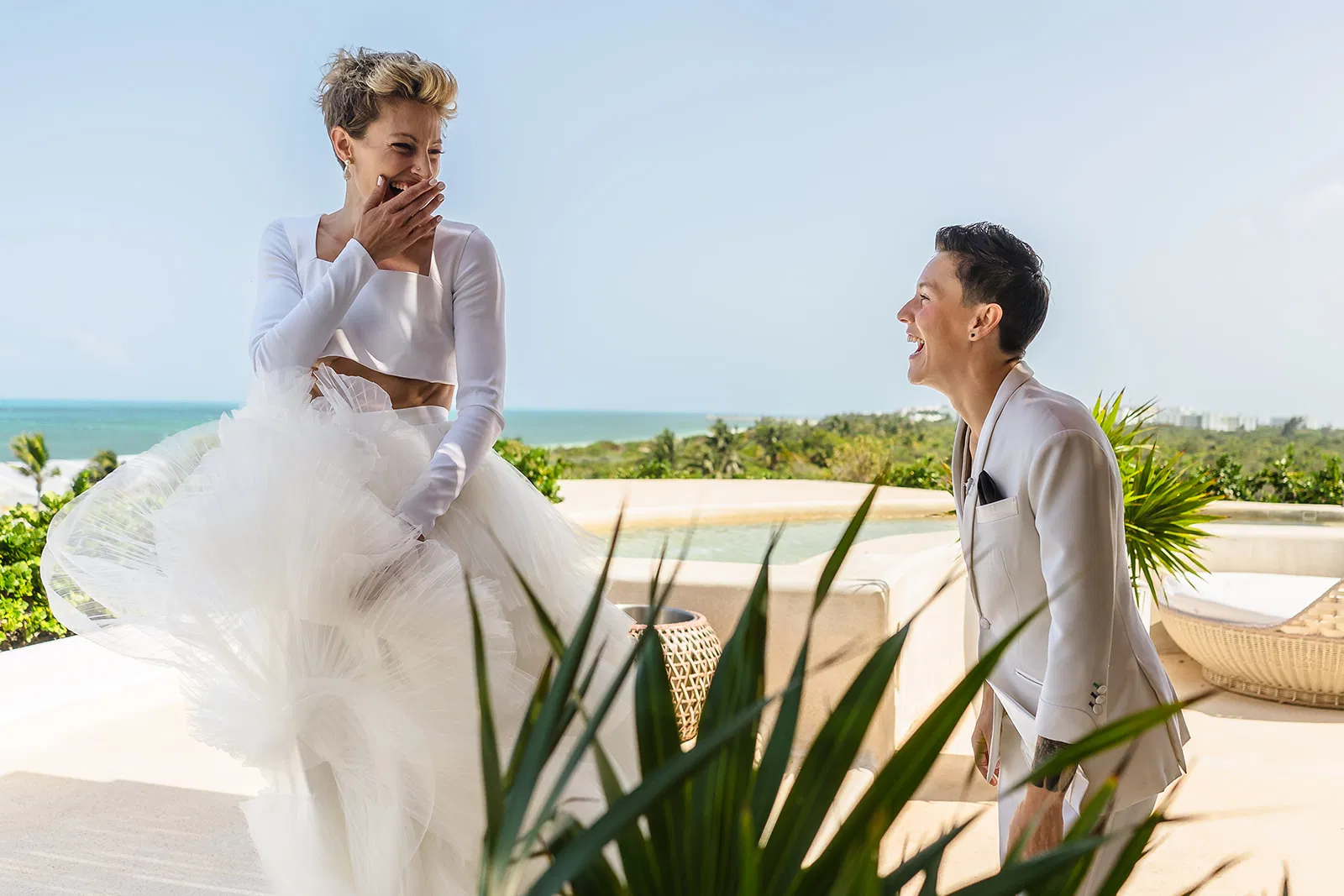 LGBTQ+ couple celebrating engagement on luxury resort terrace overlooking the Caribbean Sea in Riviera Maya