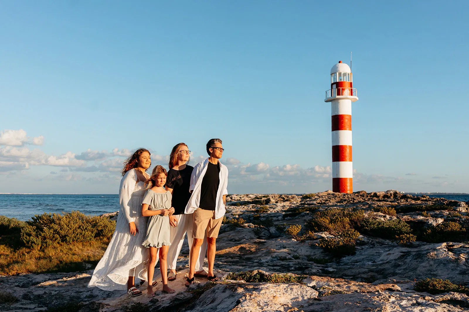 Family session at sunset in Cancun - two moms with their daughters at a lighthouse by Tam Rico Photo