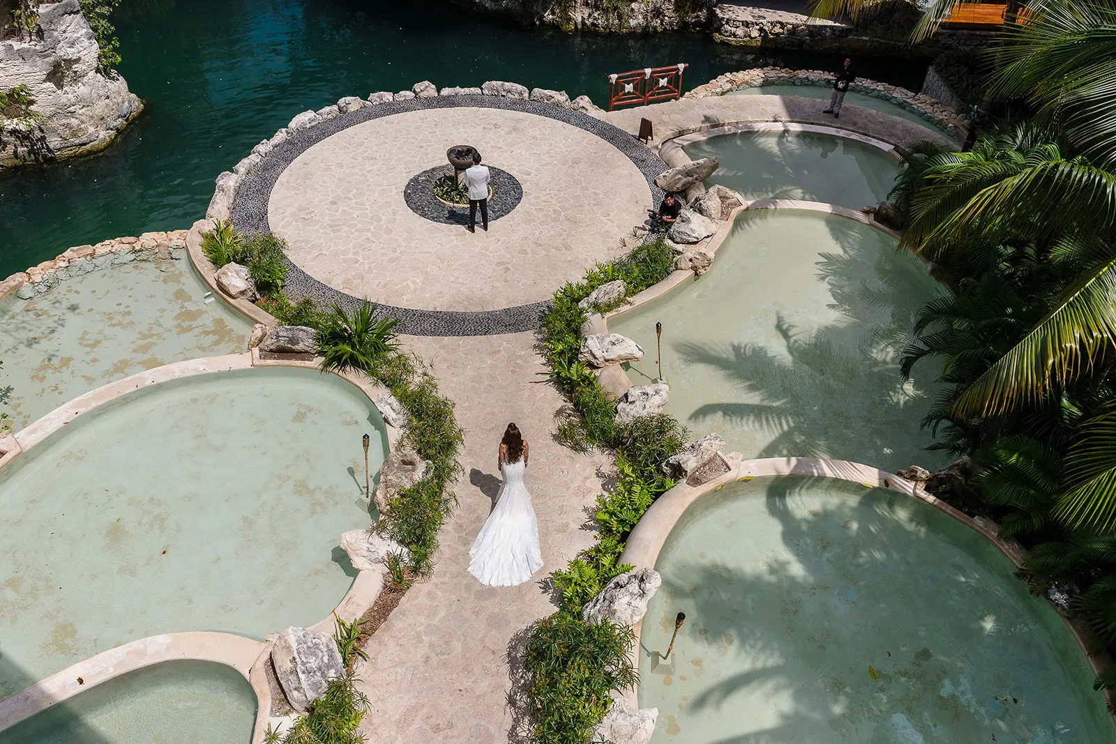 Aerial view of couple at Hotel Xcaret resort wedding venue with turquoise pools in Riviera Maya Mexico