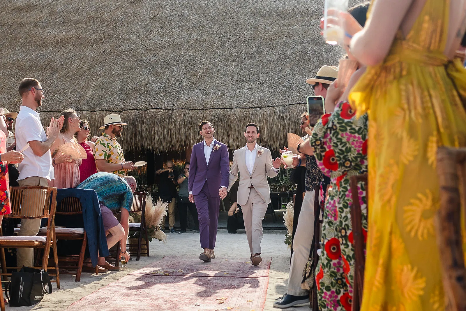 Two grooms walking down the aisle at their Blue Venado beach wedding in Riviera Maya by Tam Rico Photo