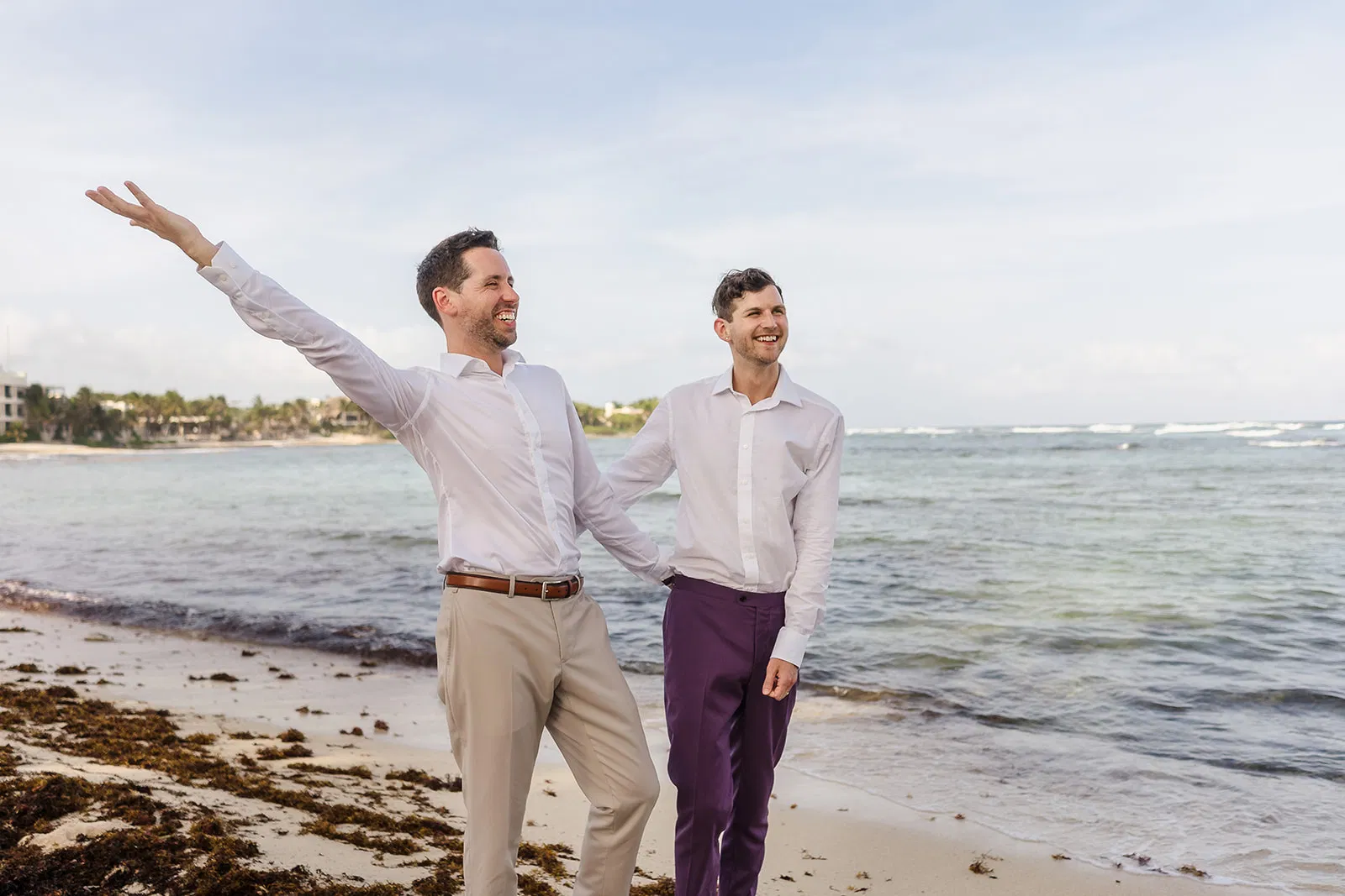 Same-sex wedding at Blue Venado Beach - two grooms celebrating on the sand by Tam Rico Photo