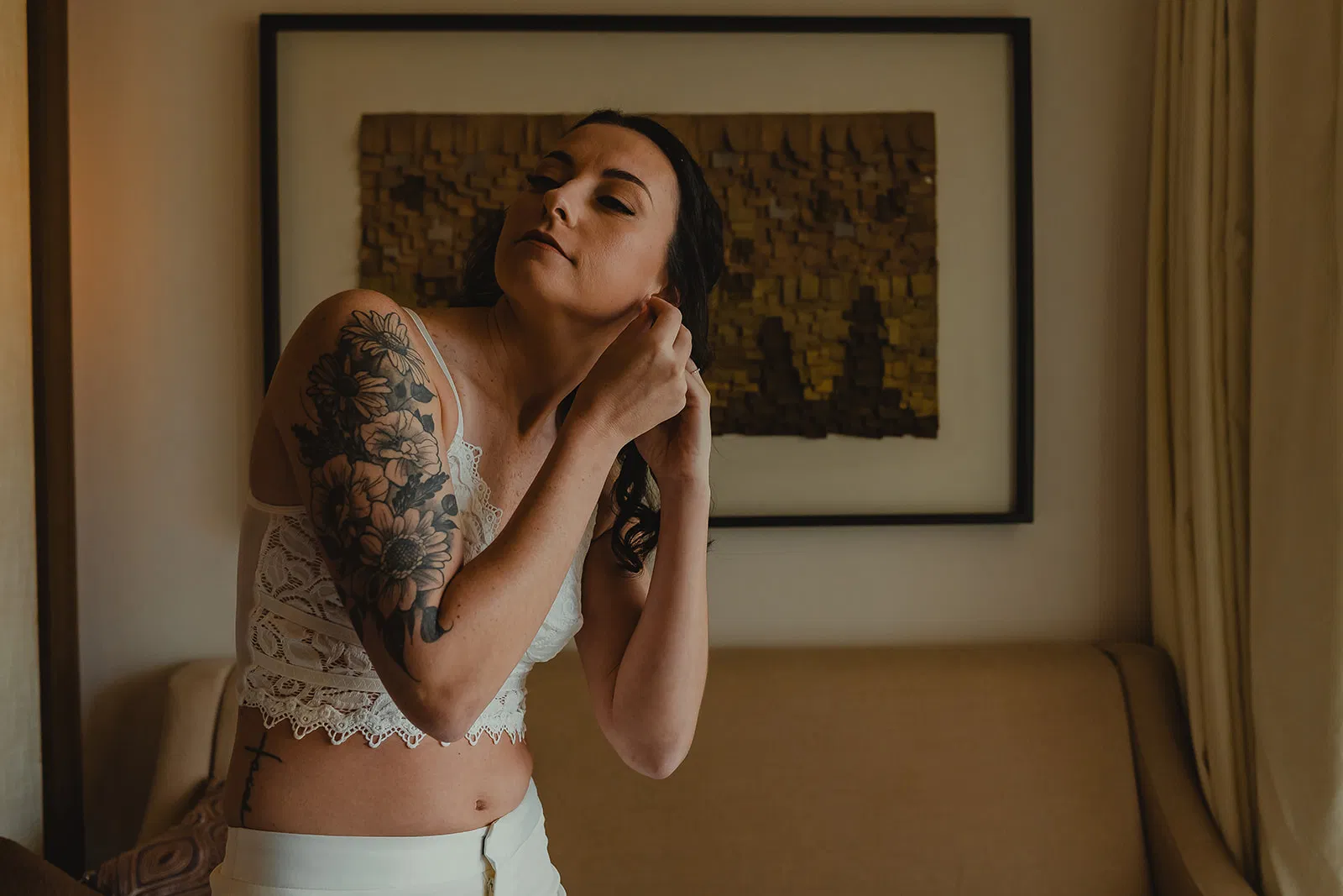 Bride with floral tattoos getting ready in white lace for LGBTQ+ wedding at Secrets Playa Mujeres Cancun