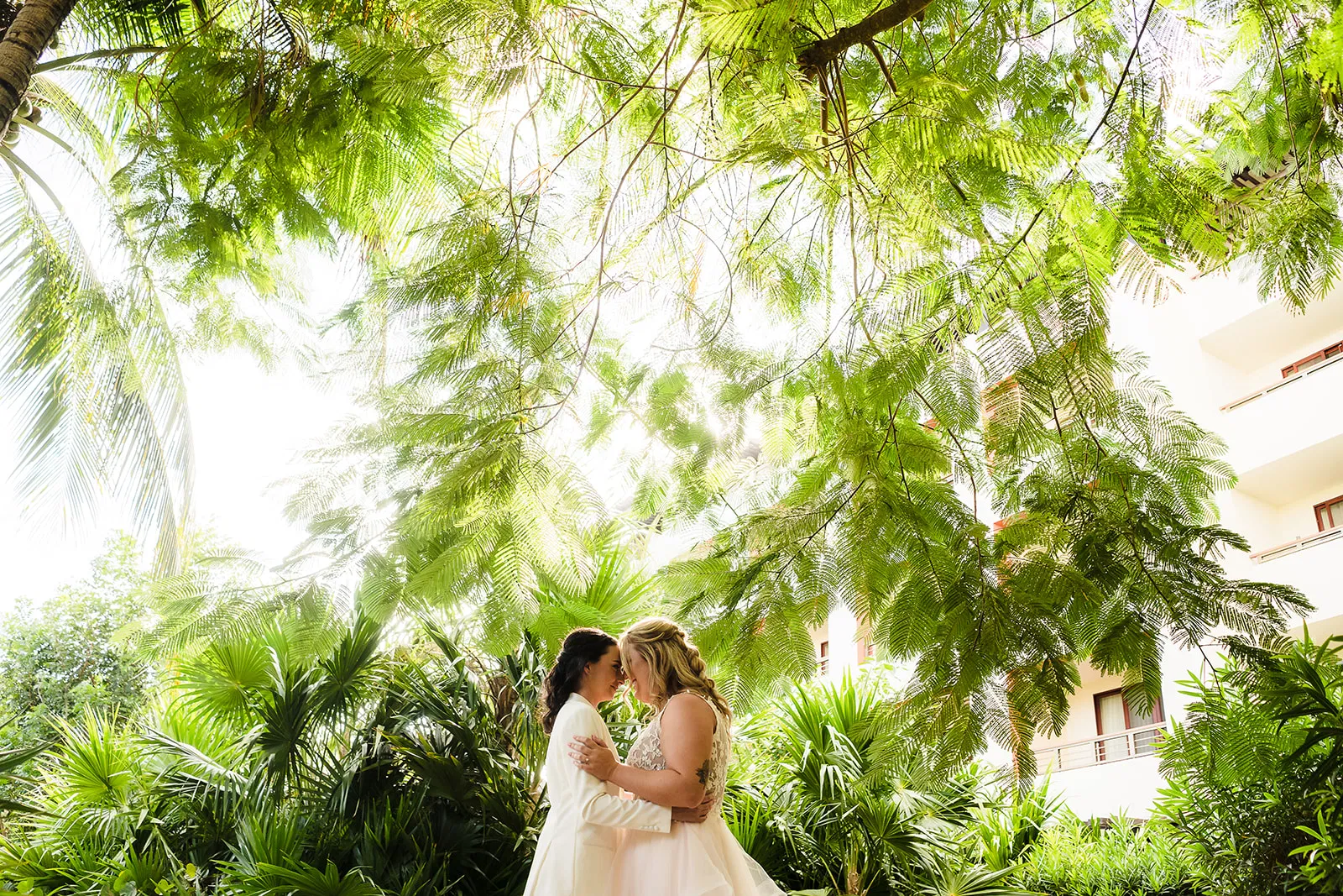 Two brides sharing first kiss at their LGBTQ+ wedding ceremony at Secrets Playa Mujeres Cancun Mexico