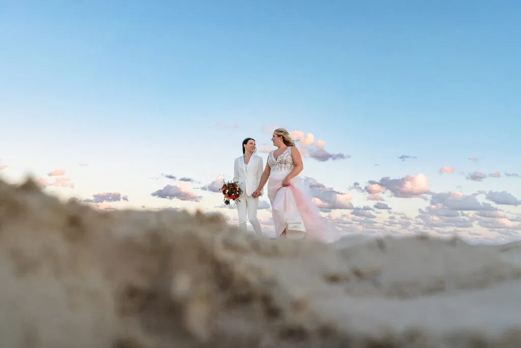 Same-sex couple wedding photography at sunset in Tulum Mexico with beautiful sky and ancient Mayan ruins backdrop