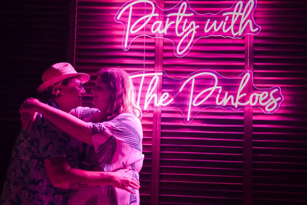 LGBTQ couple embracing under neon lights at Rosewood Mayakoba Riviera Maya Mexico same-sex wedding photography session
