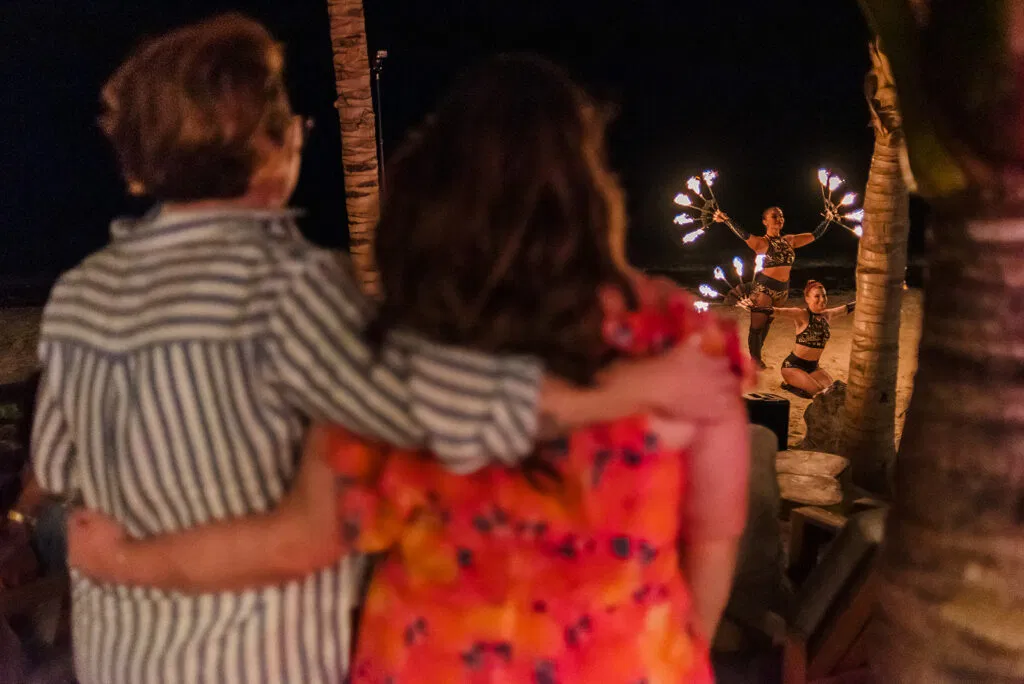 LGBTQ couple watches fire dancers perform at Rosewood Mayakoba wedding reception in Riviera Maya Mexico