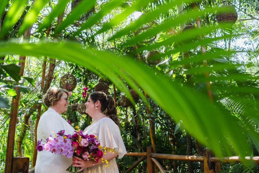 LGBTQ couple celebrates same-sex wedding at Rosewood Mayakoba with tropical flowers in lush Riviera Maya lgbtq wedding photographer in cancun mexico
