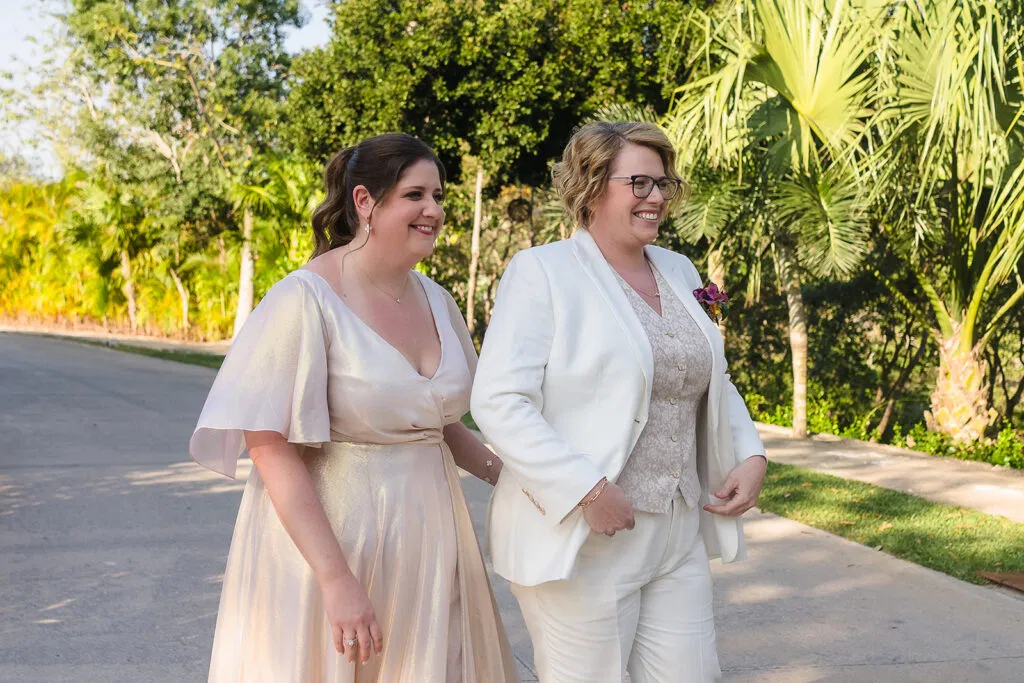 Two brides walking hand-in-hand at Rosewood Mayakoba, LGBTQ wedding photography in Riviera Maya Mexico same-sex ceremony