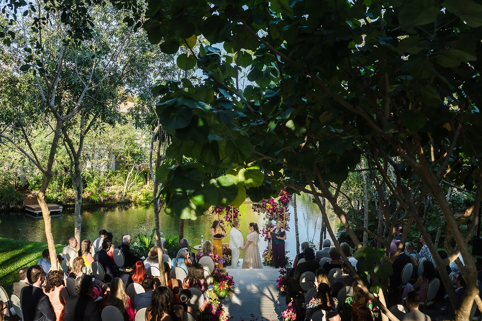 LGBTQ wedding ceremony at Rosewood Mayakoba with couple exchanging vows under lush tropical trees in Riviera Maya, Mexico